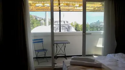 a room with a balcony with a table and a chair at Galata Fil Hotel in Istanbul