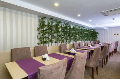 a row of tables and chairs in a room with plants at Molton Monapart Mecidiyekoy in Istanbul