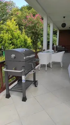 a barbecue grill on a patio with a table at family villas sapanca in Sapanca