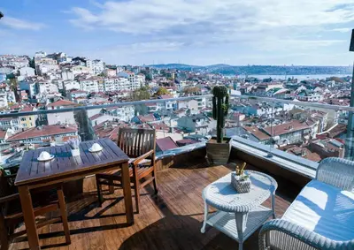 a balcony with a table and chairs overlooking a city at Hotel Bosfora in Istanbul