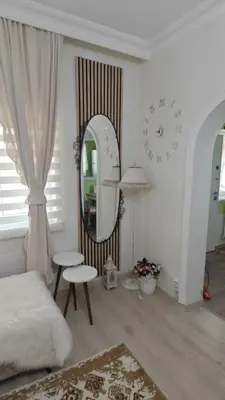 a white living room with a clock and a mirror at An Istanbul tale, an Istanbul dream, garden house in Istanbul
