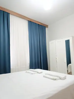 a bedroom with a white bed and blue curtains at Apartment Taksim-Beyoğlu 2 in Istanbul