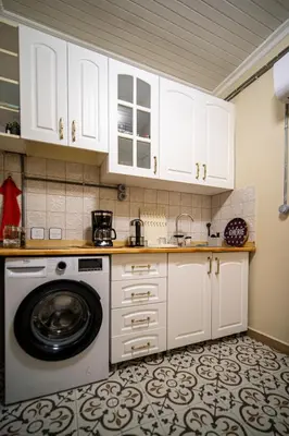 a kitchen with white cabinets and a washing machine at Mercan Apartments Balat - Mihrab Niche in Istanbul