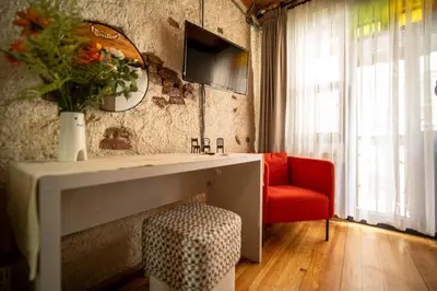 a living room with a table and a red chair at Mercan Apartments Balat-The Bay in Istanbul