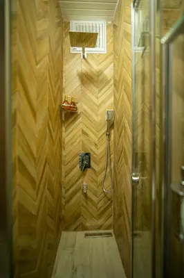 a bathroom with a shower with a wooden wall at Mercan Apartments Balat-The Bay in Istanbul