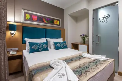 a bedroom with a large bed with a blue headboard at Ferman Hilal Hotel-Special Category in Istanbul