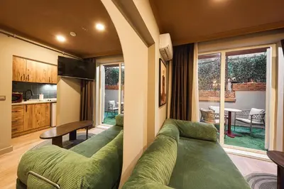 a living room with green couches and a kitchen at Tare Suites Beşiktaş in Istanbul