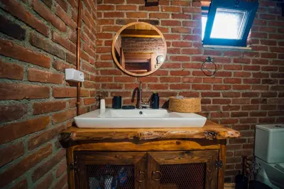 a bathroom with a white sink and a brick wall at oasis sapanca in Sapanca
