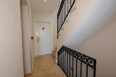 an empty hallway with stairs and a white door at T & R İstanbul hotel in Istanbul