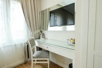 a room with a desk with a tv and a chair at T & R İstanbul hotel in Istanbul
