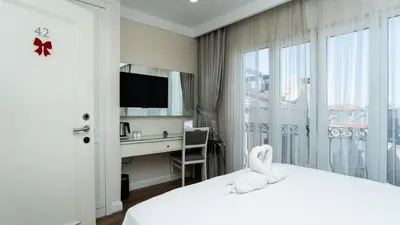 a hotel room with a bed with a desk and a window at T & R İstanbul hotel in Istanbul