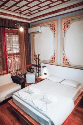 a bedroom with a white bed and a couch at Pablo suit otel in Istanbul