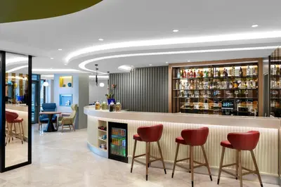 a bar in a restaurant with red bar stools at Hampton By Hilton Istanbul Sisli in Istanbul