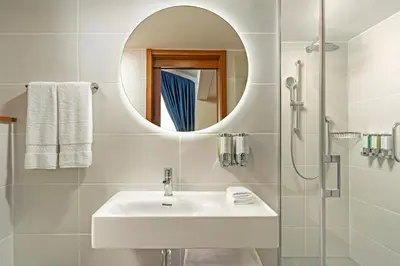 a white bathroom with a sink and a mirror at Hampton By Hilton Istanbul Sisli in Istanbul