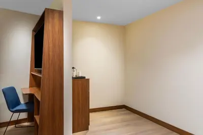 a room with a chair and a book shelf at Hampton By Hilton Istanbul Sisli in Istanbul