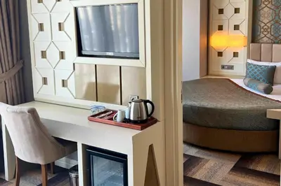 a room with a bed and a desk with a kettle on it at The Grand Mira Business Hotel in Istanbul