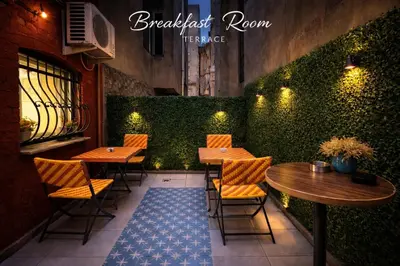 a restaurant with tables and chairs and a green hedge at Istanberry - Joker Two Bedroom Apartments in Istanbul