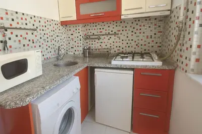 a kitchen with a stove top oven next to a washing machine at Istanberry - Joker Two Bedroom Apartments in Istanbul