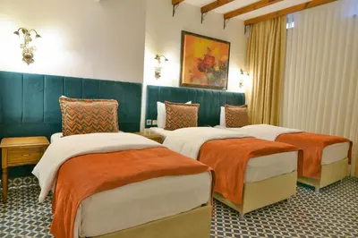 a hotel room with three beds with orange and white blankets at Istanbul Life Hotel in Istanbul