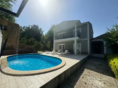 a villa with a swimming pool in front of a house at Sapanca Bizim Konak in Sapanca
