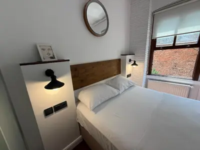 a bedroom with a white bed and a mirror at Galata Tower Suites in Istanbul