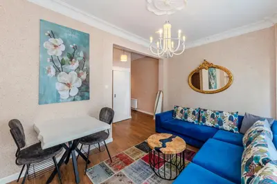 a living room with a blue couch and a table at Equipped Flat w Balcony - In The Arnavutköy - Bebek in Istanbul