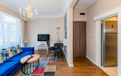 a living room with a blue couch and a table at Equipped Flat w Balcony - In The Arnavutköy - Bebek in Istanbul