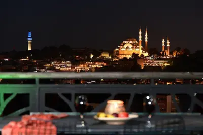 a plate of food on a table with a view of a city at night at 2BR Unique Terrace 2 AC in Beyoğlu Galata in Istanbul