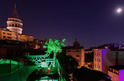 a view of a city at night with a clock tower at Historical Flat Unique Terrace AC in Beyoğlu Galata in Istanbul