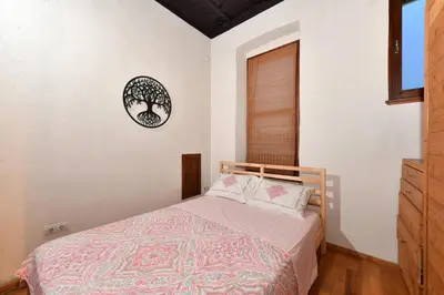 a bedroom with a bed and a clock on the wall at Historical Flat Unique Terrace AC in Beyoğlu Galata in Istanbul