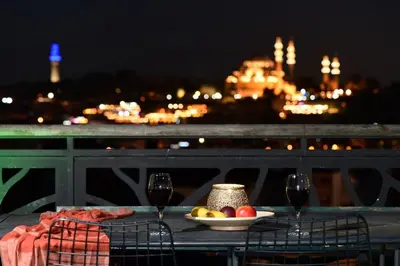 a table with a plate of food and two wine glasses at Historical Flat Unique Terrace AC in Beyoğlu Galata in Istanbul