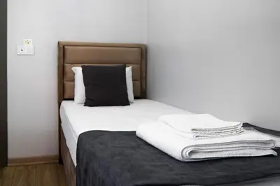 a bed with white sheets and a black pillow at Mesil Hotel in Istanbul