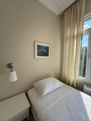 a small bedroom with a bed and a window at The Kinyas House - Apartment in Kadıköy Historical Fishermen's Market in Istanbul