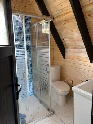 a bathroom with a shower with a toilet and a sink at Karahan bungalov in Tayakadın