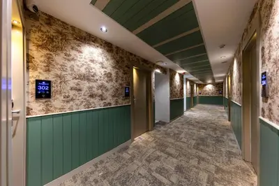 a hallway with green walls and tile floors at Çorlu Temel Hotel in Corlu