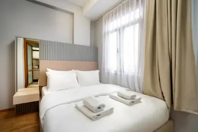 a bedroom with a white bed with two towels on it at Pia Homes- Gümüşsuyu in Istanbul