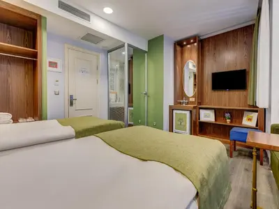 two beds in a bedroom with green walls at Sometimes Hotel Taksim in Istanbul