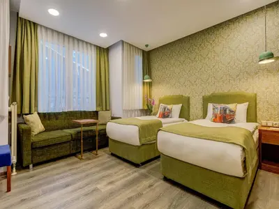 a hotel room with two beds and a couch at Sometimes Hotel Taksim in Istanbul
