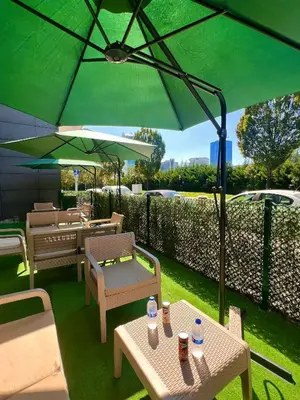 a patio with tables and chairs and an umbrella at GÜNEŞLİ SUİT OTEl in Istanbul