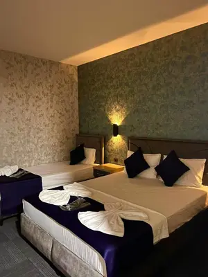 a hotel room with two beds in a room at GÜNEŞLİ SUİT OTEl in Istanbul