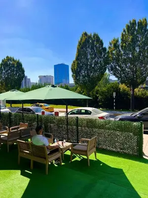 a man sitting at a table under an umbrella at GÜNEŞLİ SUİT OTEl in Istanbul