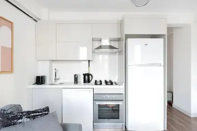 a kitchen with white cabinets and a refrigerator at Elegant & Charming Apartment in Beyoglu in Istanbul