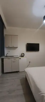 a white room with a bed and a kitchen at Şişli Suites - Room22 in Istanbul