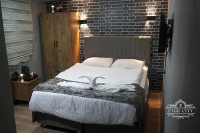 two birds sitting on a bed in a bedroom at Emir City Hotel in Bursa