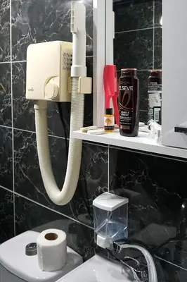 a bathroom with a phone on the wall above a sink at Emir City Hotel in Bursa