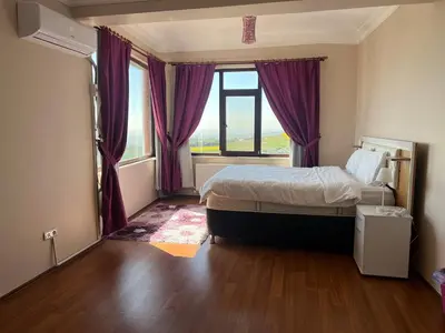 a bedroom with a bed and a window with purple curtains at Luxury Mansion Amazing View, Hidden Garden in Celâliye