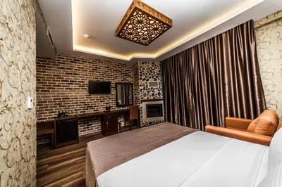a bedroom with a bed and a tv and a brick wall at My Green Otel in Sapanca