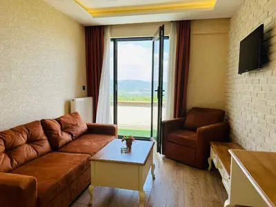 a living room with a couch and a table and a window at My Green Otel in Sapanca