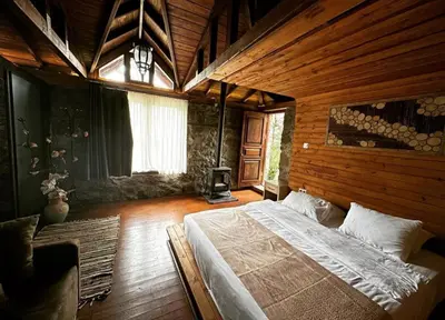 a bedroom with a large bed in a wooden room at My Green Otel in Sapanca