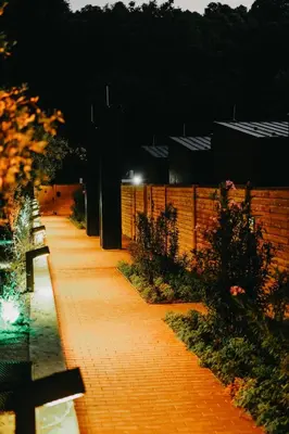 a brick pathway at night with a fence at Melekona House in Kartepe